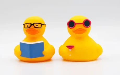 Yellow rubber duck sitting next to an open notebook illustrating the writing to learn strategy and problem solving concept