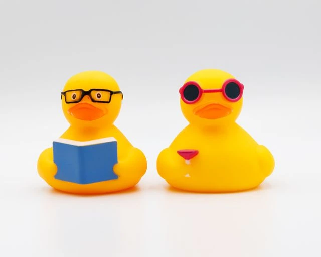 Yellow rubber duck sitting next to an open notebook illustrating the writing to learn strategy and problem solving concept