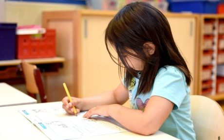 First-grade child tracing letters using phonics-based letter sequence worksheet